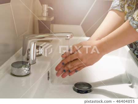 women washing hands under the water faucet women washing hands under the water faucet 46404855