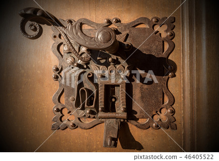 Ancient wrought iron lock of a door with keyholes Ancient wrought iron lock of a door with keyholes 46405522