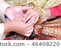 Thai wedding groom putting a ring on finger. 46408220