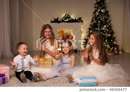 the little boy and three girls open Gifts Christmas new year tree Garland 46409477