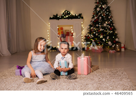 the little boy and girl open Christmas presents Christmas tree new year's Eve family celebration 46409565