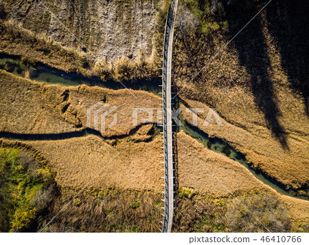 Wooden bridge over dry grassland,aerial view.  46410766