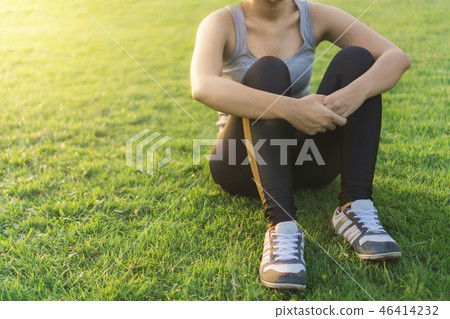 woman runner sitting on green grass  46414232