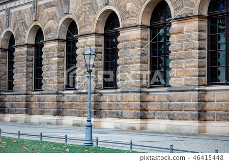 Metal vintage street pole lamp near old building  46415448