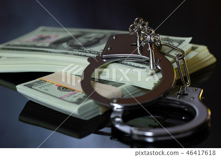 Handcuffs and money in the darkness. 46417618