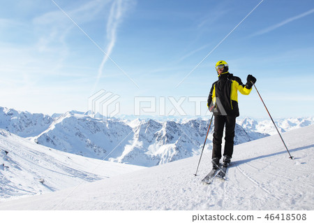 Skier standing on mountain slope Skier standing on mountain slope 46418508