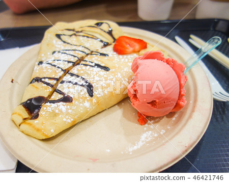 Big crepe with chocolate sauce and strawberry ice cream 46421746