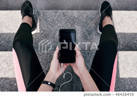 Fitness runner on mobile smart phone app tracking progress listening to music with earphones for Fitness runner on mobile smart phone app tracking progress listening to music with earphones for 46426459