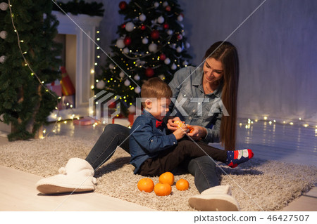 mother and son eat tangerines at Christmas new year mother and son eat tangerines at Christmas new year 46427507