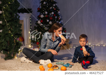 mom and son eat at Christmas tree with lights 46427527
