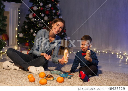 mom and son eat at Christmas tree with lights mom and son eat at Christmas tree with lights 46427529