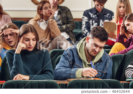 The group of cheerful happy students sitting in a lecture hall before lesson The group of cheerful happy students sitting in a lecture hall before lesson 46432644