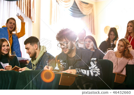 The group of cheerful happy students sitting in a lecture hall before lesson The group of cheerful happy students sitting in a lecture hall before lesson 46432660