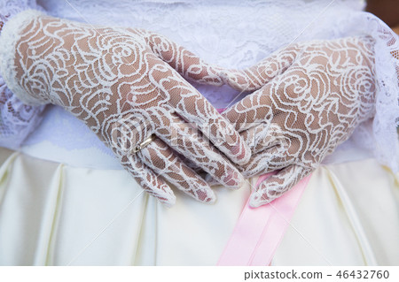 Wedding gloves of lace on hands of bride. Wedding gloves of lace on hands of bride. 46432760