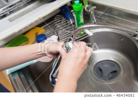 Woman cleaning the kitchen sink 46434081
