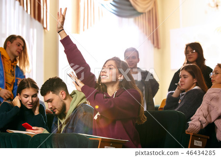 The group of cheerful happy students sitting in a lecture hall before lesson 46434285
