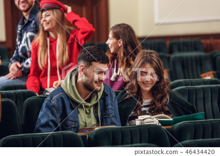 The group of cheerful happy students sitting in a lecture hall before lesson 46434420