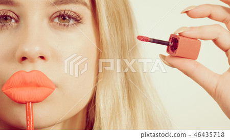 Woman applying lipstick or lip gloss Woman applying lipstick or lip gloss 46435718