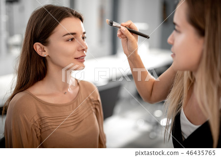 Makeup artist is applying tonal cream for girl 46435765