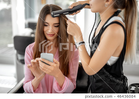 Beautiful woman is sitting with gadget in beauty salon Beautiful woman is sitting with gadget in beauty salon 46436084