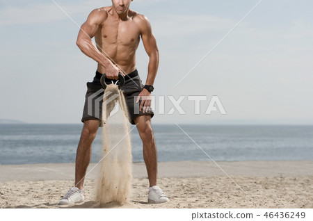 Man with a naked body doing kettlebell exercise Man with a naked body doing kettlebell exercise 46436249
