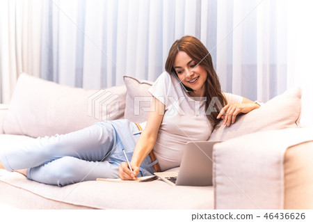 Busy joyous woman writing while being on sofa Busy joyous woman writing while being on sofa 46436626
