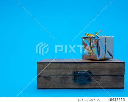 small shiny gift box on wooden chest 46437353