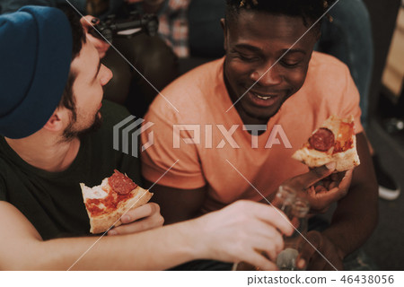 Two male friends enjoying food and drinks at home 46438056