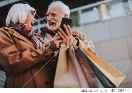 Happy elderly couple using smartphone on the street Happy elderly couple using smartphone on the street 46439944