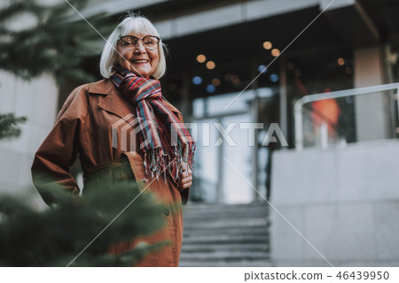 Joyful senior woman in glasses posing on the street Joyful senior woman in glasses posing on the street 46439950