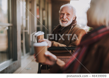 Joyful old man spending time with wife at outdoor cafe 46439999