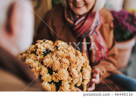 Smiling senior woman accepting present from loving husband Smiling senior woman accepting present from loving husband 46440116