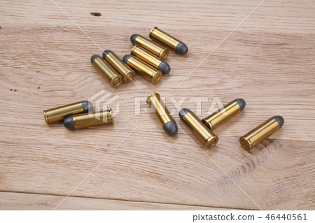 The .45 Revolver cartridges on wooden background 46440561
