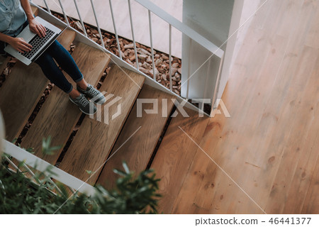 Young lady in jeans working on latop 46441377