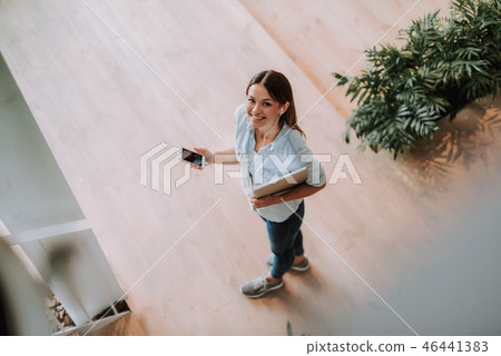 Beautiful young woman listening music on smartphone 46441383