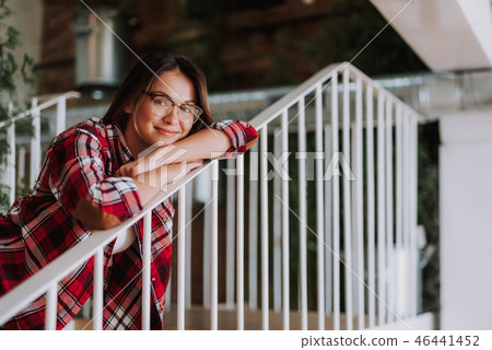 Charming lady in glasses leaning on stair railing 46441452