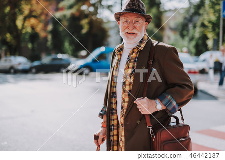 Smiling old male walking across the street 46442187