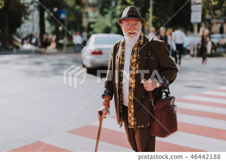 Cheerful old male walking across the street Cheerful old male walking across the street 46442188