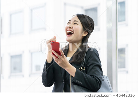 Woman receiving good news on her smartphone Woman receiving good news on her smartphone 46442330