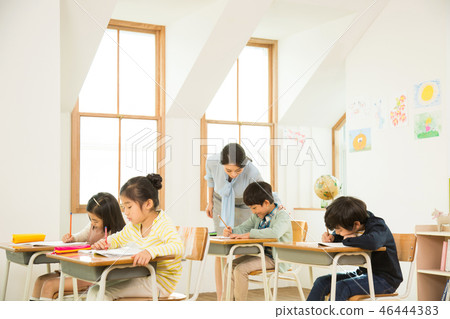 Female Teacher Assisting A Young Student Female Teacher Assisting A Young Student 46444383