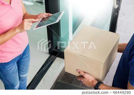 woman courier holding a parcel Shipping Mail appending signature woman courier holding a parcel Shipping Mail appending signature 46449290