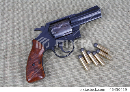Revolver with ammunition on the canvas background Revolver with ammunition on the canvas background 46450439