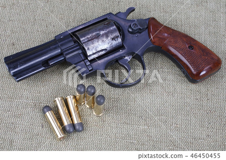 Revolver with ammunition on the canvas background Revolver with ammunition on the canvas background 46450455