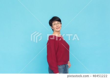 Fashion, people and style concept - Mid-aged woman in crimson sweater on blue background with copy Fashion, people and style concept - Mid-aged woman in crimson sweater on blue background with copy 46451222