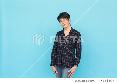 Modern woman and style concept - Beautiful mid-aged woman with short hair on blue background with 46451302