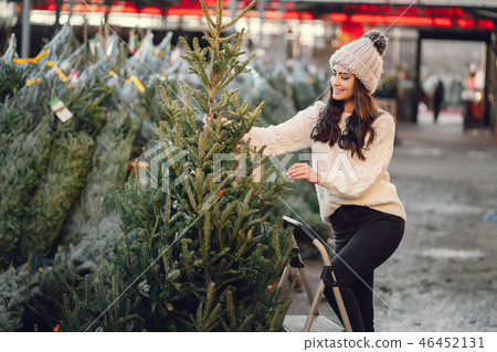 Cute brunette in a white sweater with Christmas tree Cute brunette in a white sweater with Christmas tree 46452131