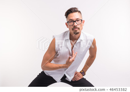 People, clothing and style concept - young sexy handsome man posing in white shirt on white 46453382