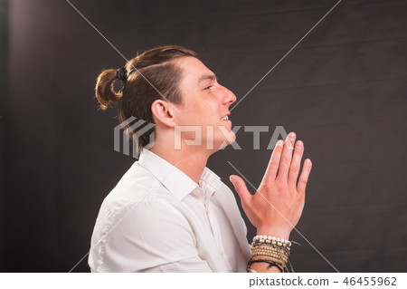 Culture, religion, people concept - handsome man in white shirt praying over grey background and Culture, religion, people concept - handsome man in white shirt praying over grey background and 46455962