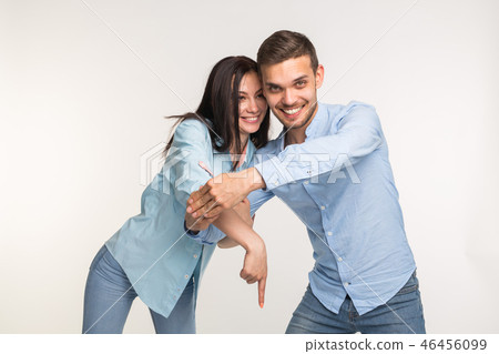 People and gesture concept - young pretty woman and handsome man pointing down over white background People and gesture concept - young pretty woman and handsome man pointing down over white background 46456099
