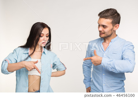 People and gesture concept - young pretty woman and handsome man pointing down over white background People and gesture concept - young pretty woman and handsome man pointing down over white background 46456100